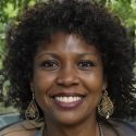 A woman with curly hair smiling for the camera in the san francisco bay area. A woman with curly hair smiling for the camera in the San Francisco Bay Area.